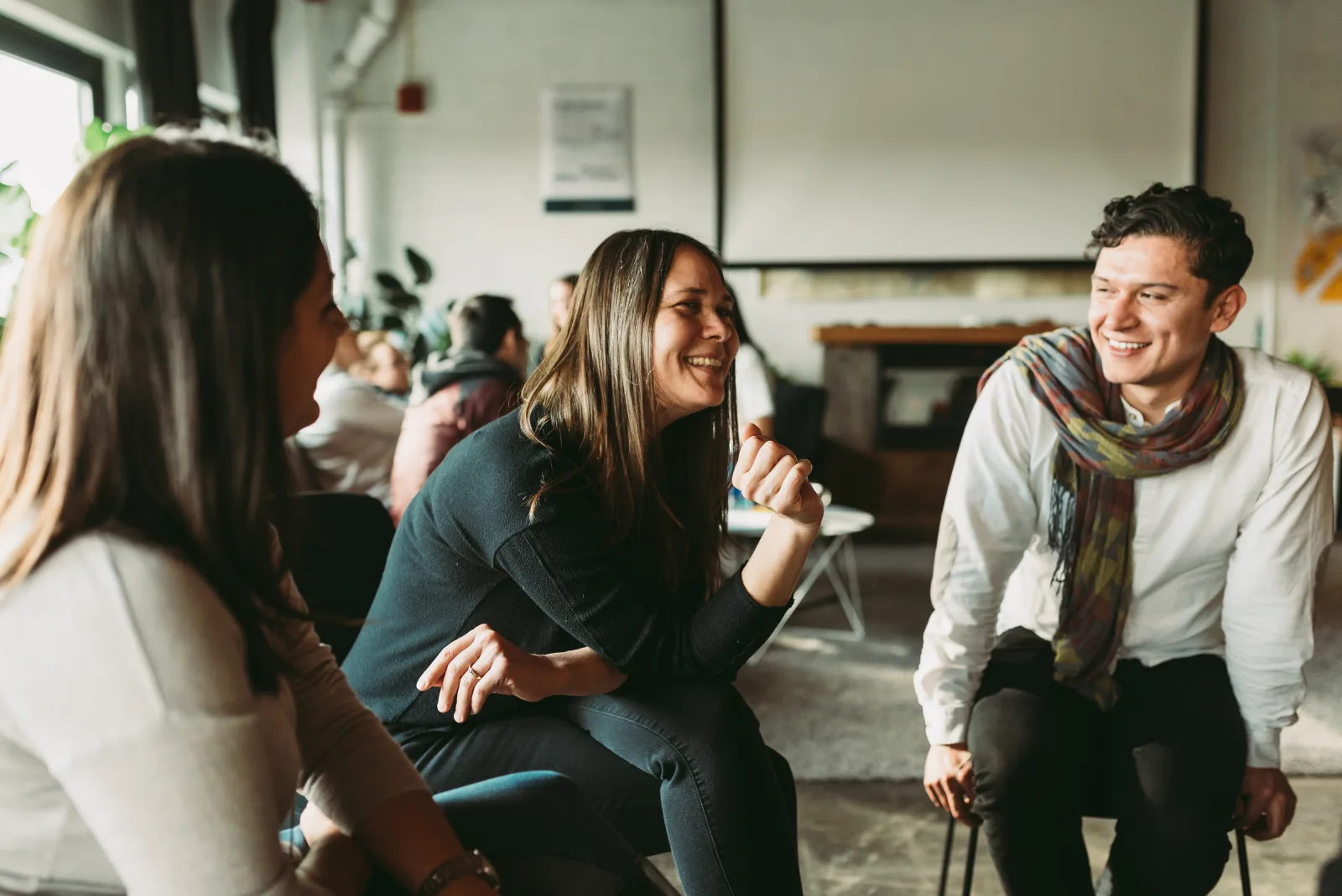 Three HumanSide participants laughing together during a live working session.